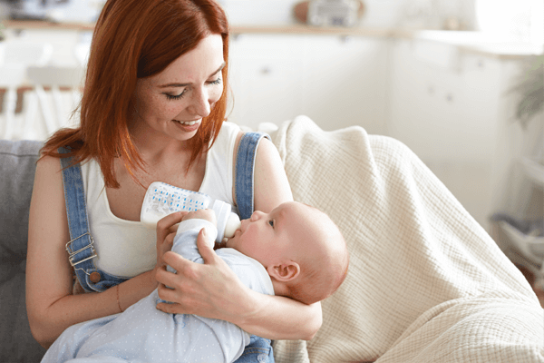 Madre usando el biberón durante la lactancia mixta